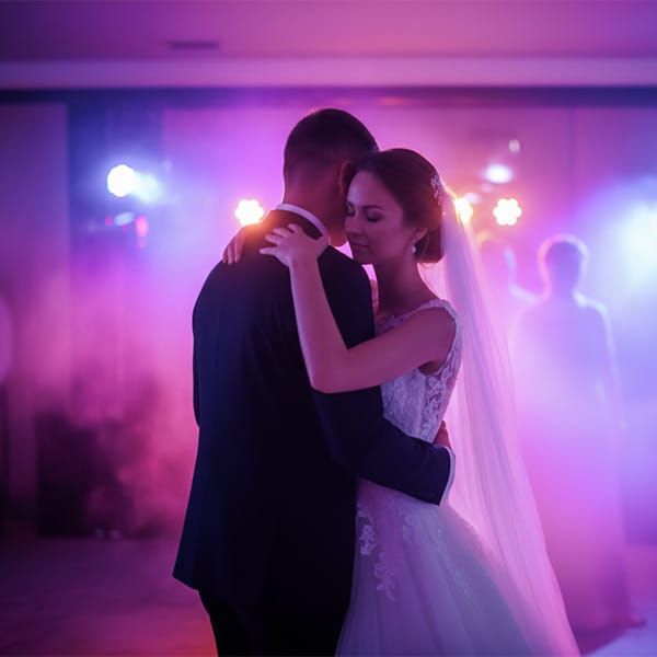 ie Silhouette des Bräutigams, der seine Braut im Arm hält, vor einem violetten Abendhimmel in Kassel.