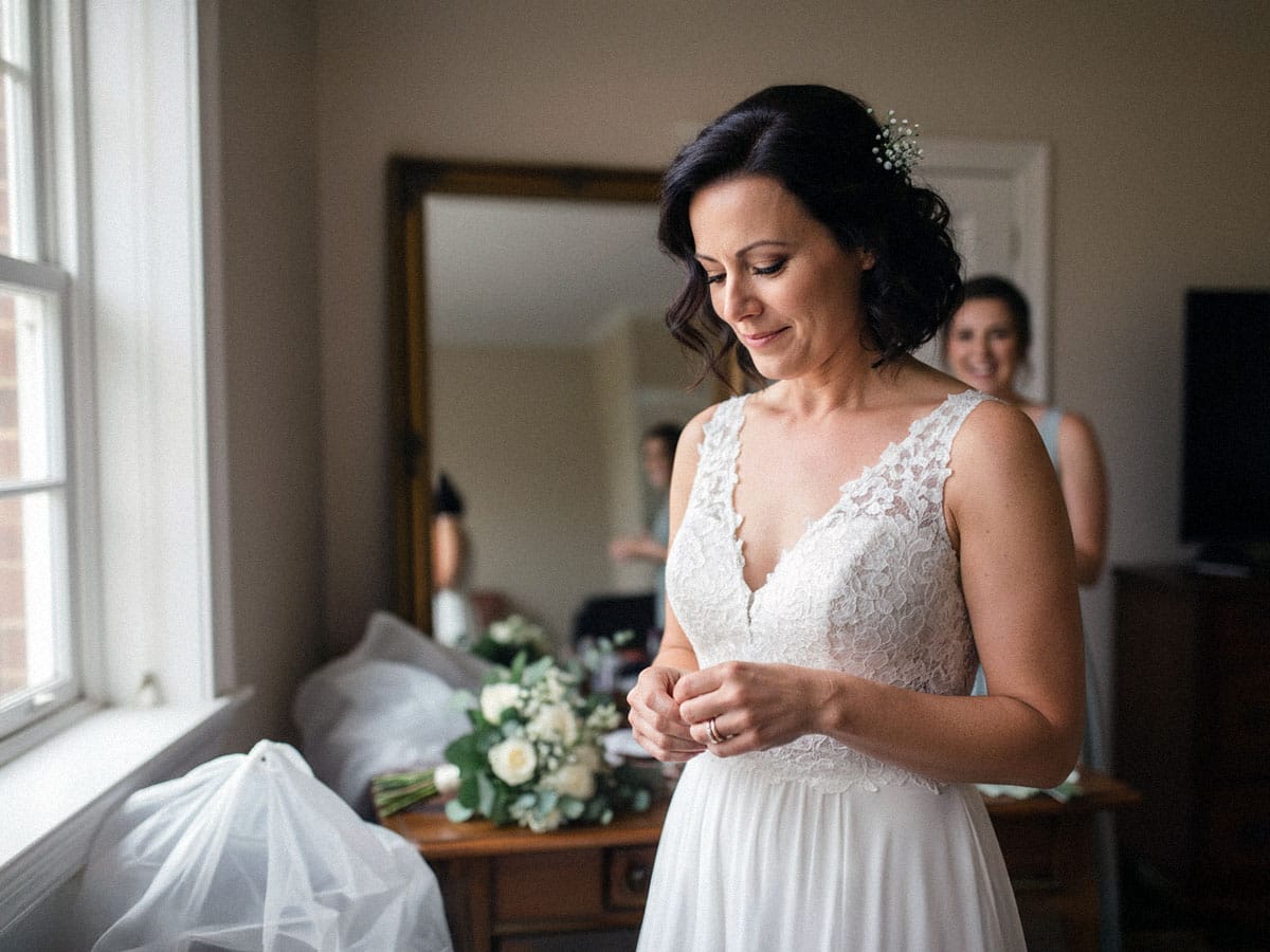 Die Braut betrachtet ihr Spiegelbild, während sie sich auf ihre Hochzeit in Kassel vorbereitet.