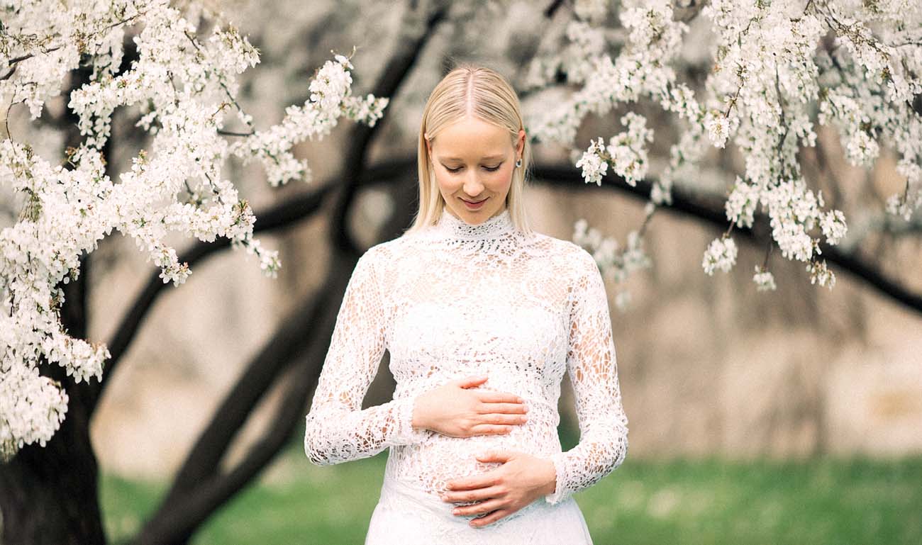 Schwangere Braut unter Kirschblüten, zarte Pastelltöne – Babybauchporträt Hochzeitsfotograf Kassel