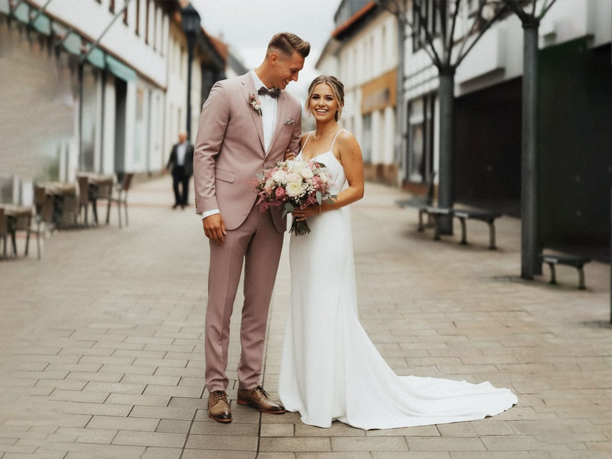 Ein lachendes Brautpaar bei einem ungezwungenen Spaziergang an ihrem Hochzeitstag in Kassel.
