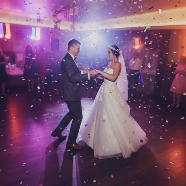 Die Silhouette eines Brautpaares, das sich bei einem farbenprächtigen Sonnenuntergang in Kassel umarmt.