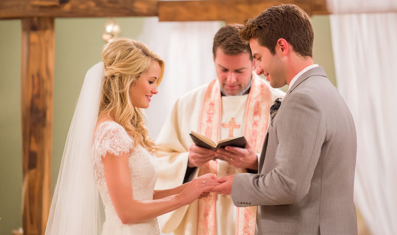 Brautpaar tauscht Ringe bei kirchlicher Trauung – professionelle Hochzeitsfotografie Kassel