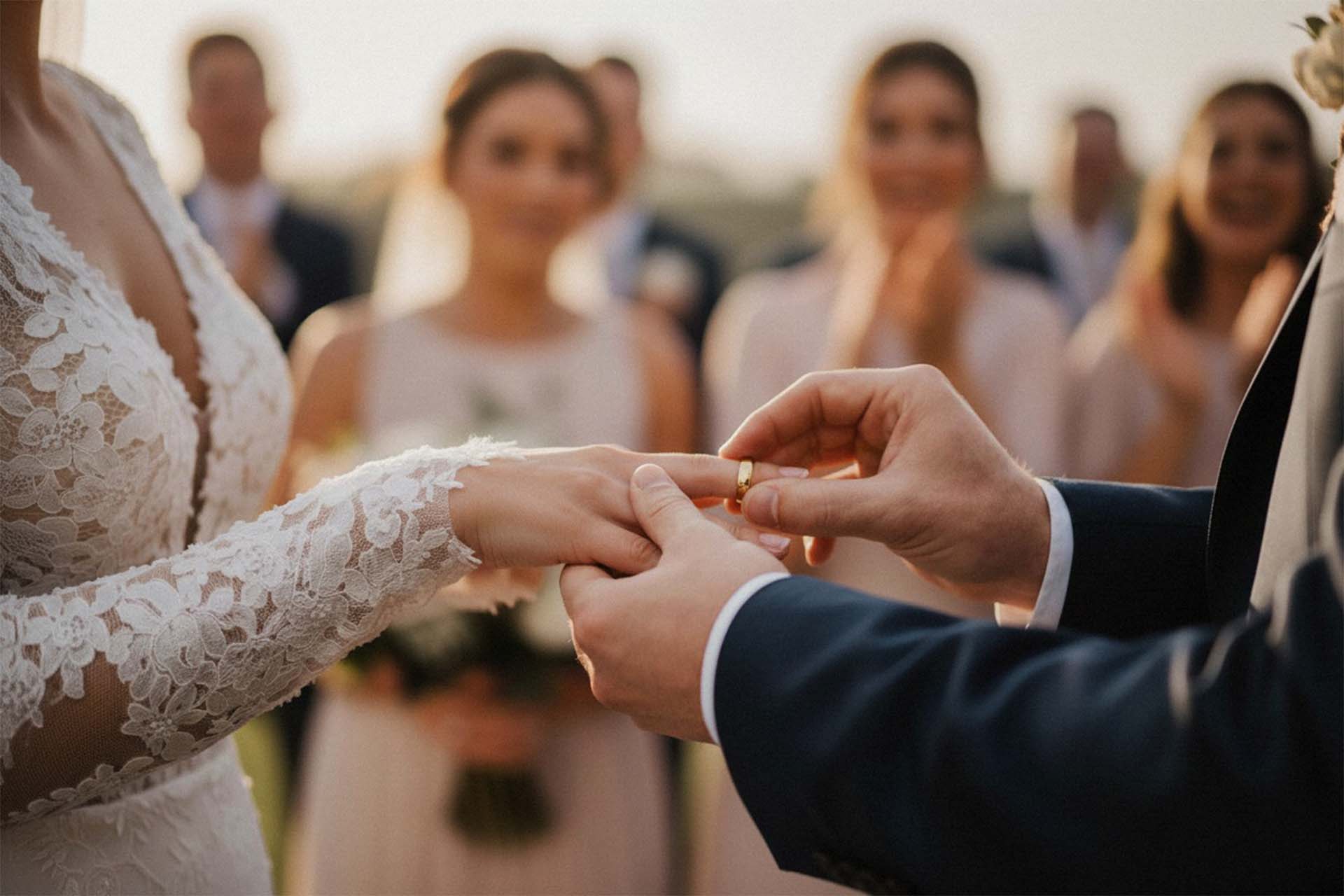 Eine Nahaufnahme der Hände des Brautpaares bei der Ringübergabe während einer Trauung im Freien in Kassel.