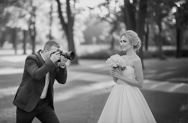 Das Brautpaar Radu und seine Partnerin gehen Hand in Hand bei ihrer Hochzeit in Kassel, fotografiert in schwarz-weiss.